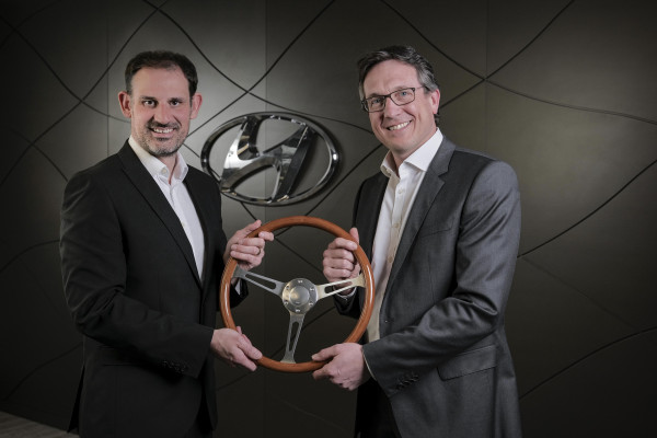 Ashley Andrew (right), MD, Hyundai UK receives the UK Car of the Year 2022 trophy from John Challen (left), director of the UK Car of the Year