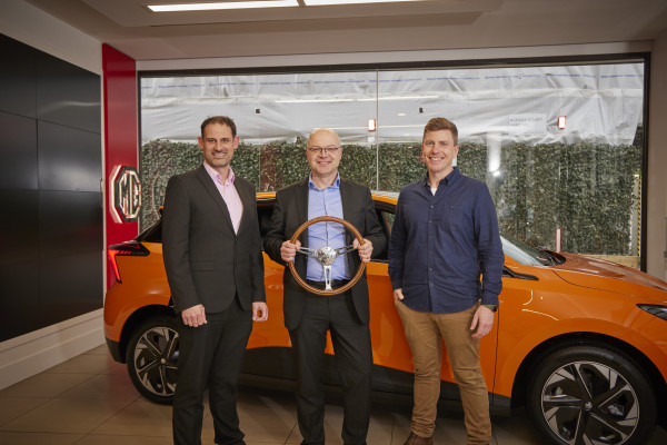 David Allison (centre), head of product & planning, MG UK, receives the UK Car of the Year 2023 trophy from John Challen (left), director of the UK Car of the Year Awards, and Chris Evans (right), head of sales at heycar