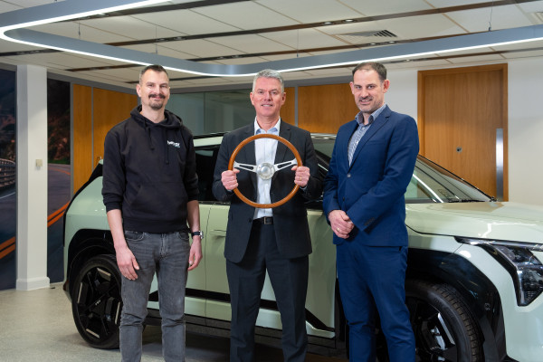 Paul Philpott (centre), president and CEO, Kia UK, receives the UK Car of the Year 2025 trophy from Matt Robinson (left), car reviews editor at heycar UK and John Challen (right), director, UK Car of the Year Awards 